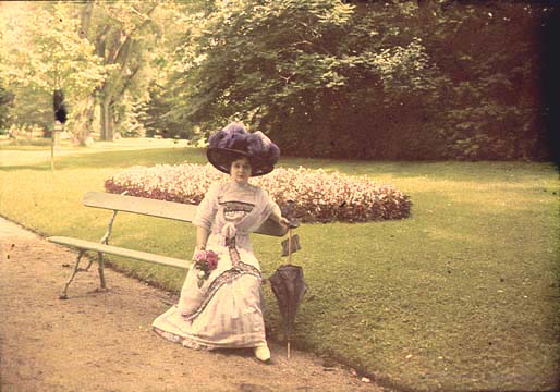 Woman Sitting on Bench in Park with Her Parasol