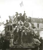 Robert Capa - A Crowd Waving American Flags and Perched on a Truck during the Liberation of France during WWII