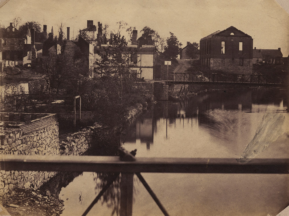 Charles E. Meyer - Ruin in Chambersburg, PA: View of Conococheague Creek South to Baptist Church and Gas Works (Photographer was standing on the bridge at Lincoln Way West.  The bridge in the distance is Burkhart Ave.)