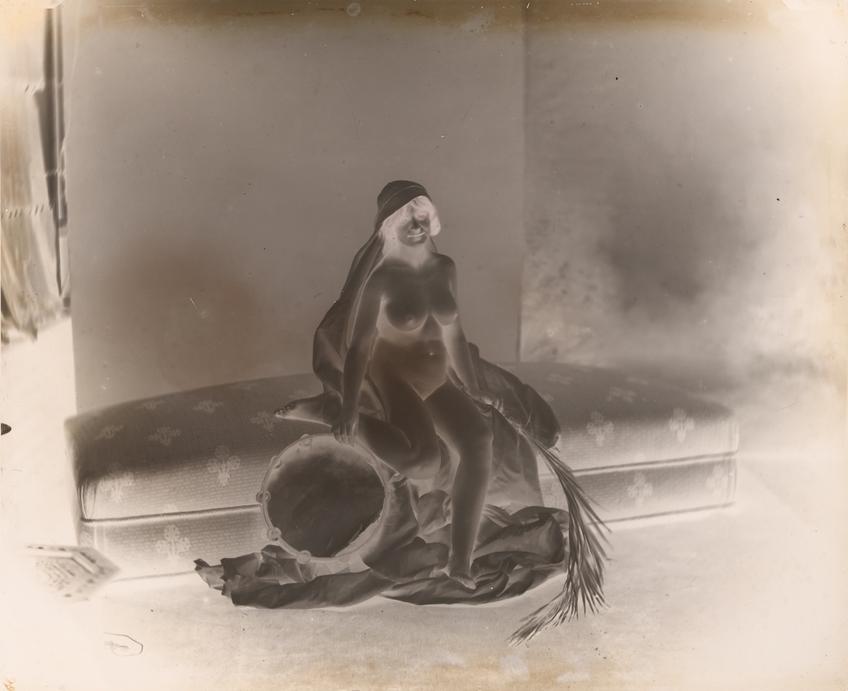 H.? - Female Nude Seated on Couch with Tambourine